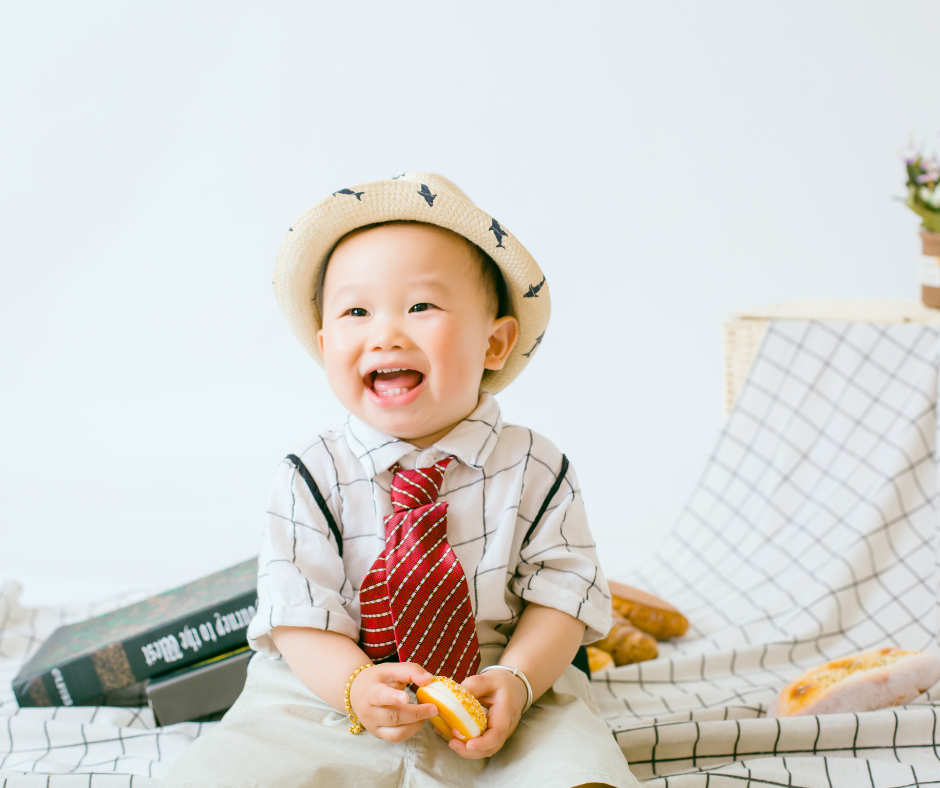 Smiling baby boy in a cute outfit during an outdoor photoshoot